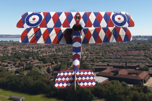 Sopwith Camel com pintura histórica Harlequin sobrevoando a cidade